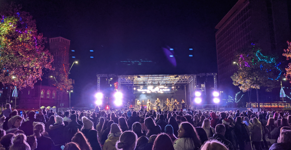 A crowd gathering in front of a stage at the Plymouth City Centre Christmas Lights Switch On